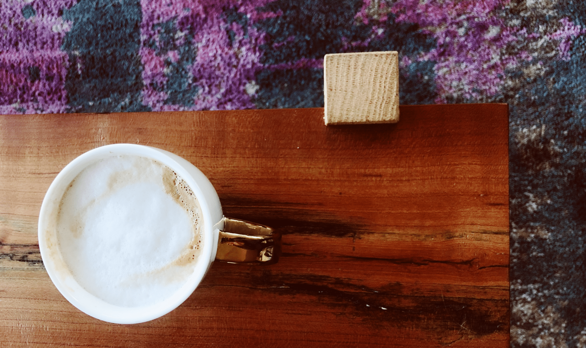 A latte sitting on a wooden coffee table